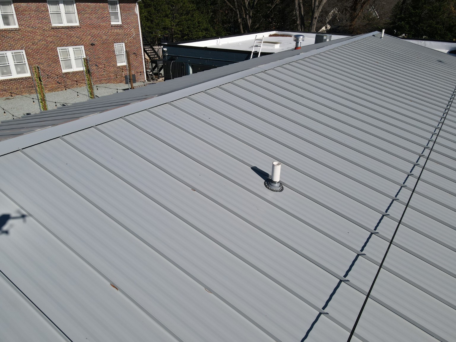 Close view of standing seam metal roofing and pipe flashing at Durham Beer Garden
