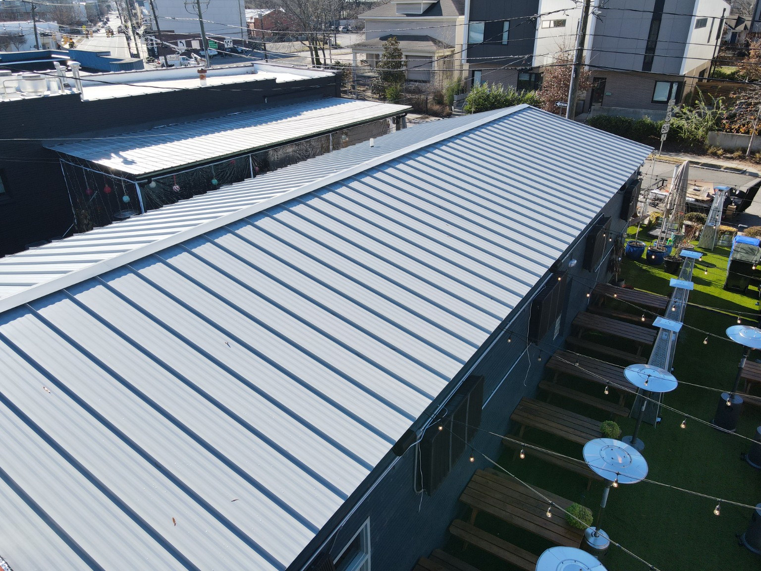 Standing seam metal roof beside the Durham Beer Garden outdoor seating area