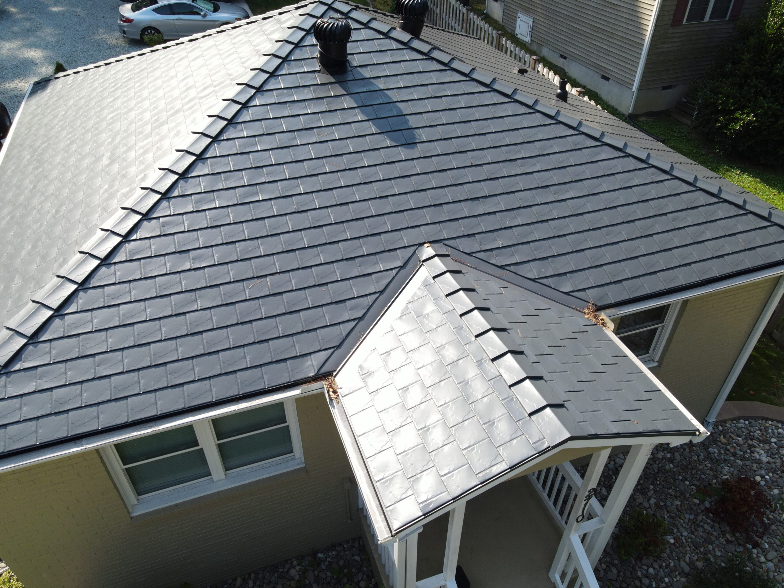 Detailed aerial view of the installed Interlock Deep Charcoal Slate metal roof on a Durham NC home's porch and hip roof
