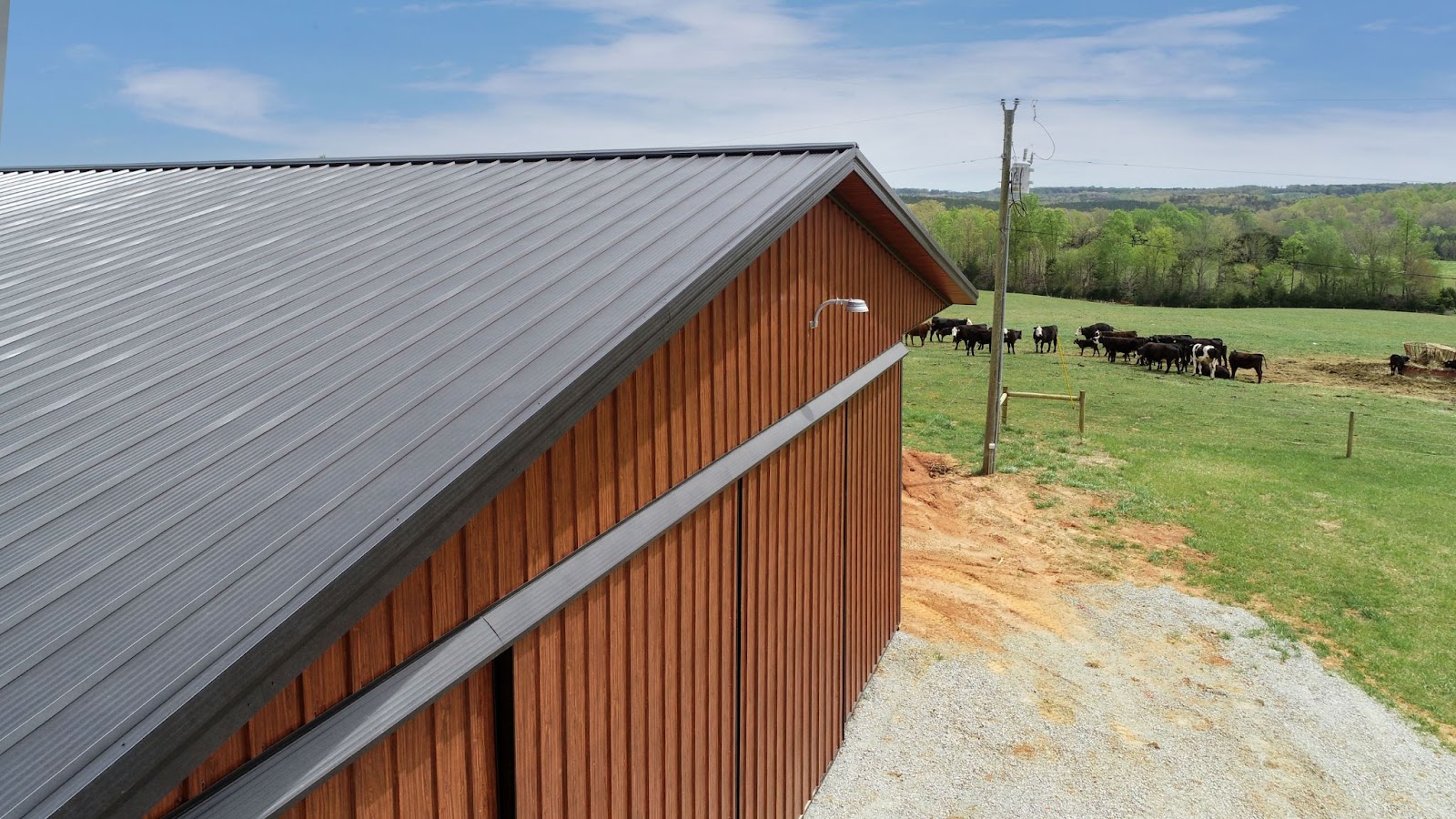 Manufacturer example of a dark concealed-fastener metal roof with clean panel lines on a wood-clad building