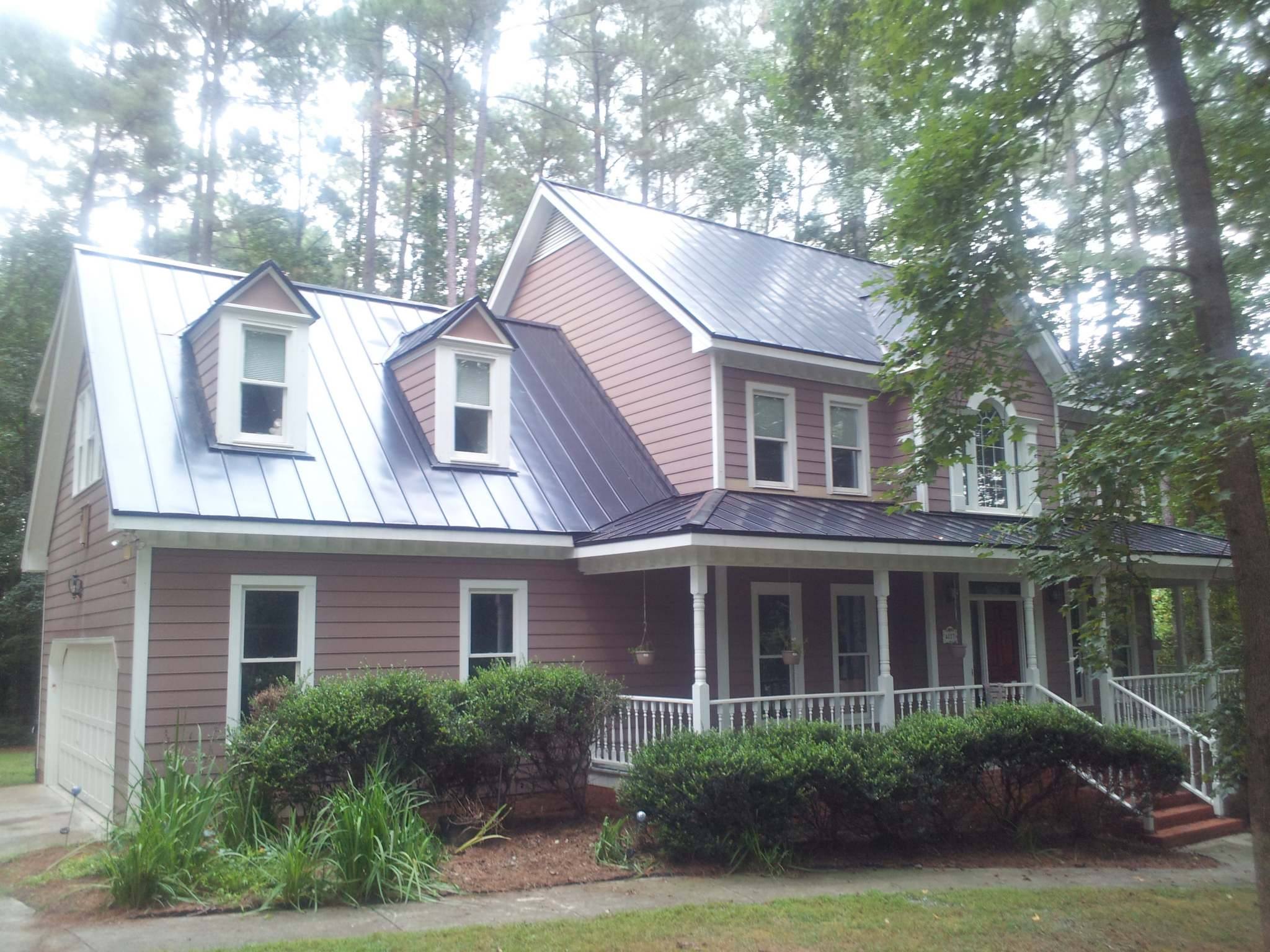 Nailstrip standing seam metal roof on a red-sided Raleigh home with dormers, gables and a front porch